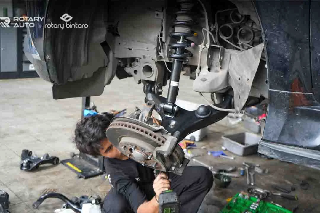 Teknisi sedang memasang kembali shockbreaker 
