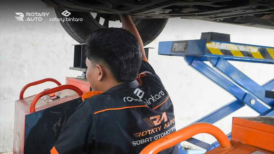 Teknisi sedang mendiagnosis kaki kaki mobil berbunyi decit dengan teknologi shaking machine dan mengatasinya